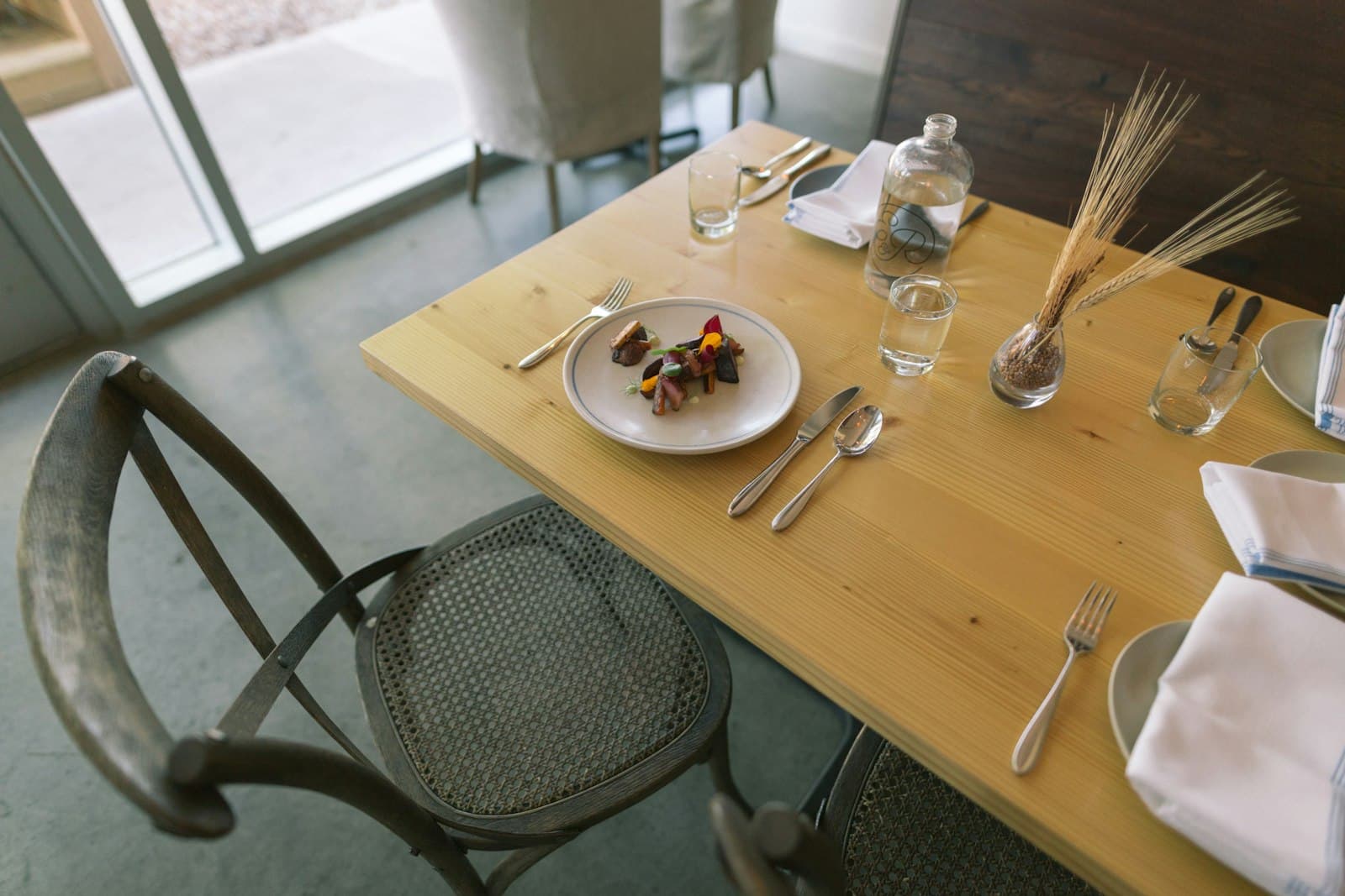A white ceramic plate set with silver cutlery on a table